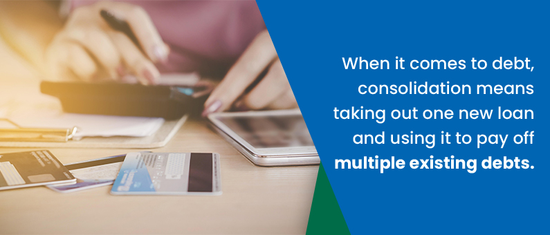 When it comes to debt, consolidation means taking out a new loan and using it pay off multiple existing loans - Close up of a person with a calculator and credit cards
