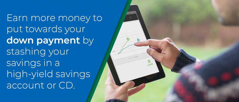 Earn more money to put  towards your down payment by stashing  your savings in a high-yield savings account or CD - Person touching a tablet with a graph