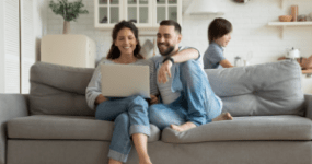 people on couch with laptop