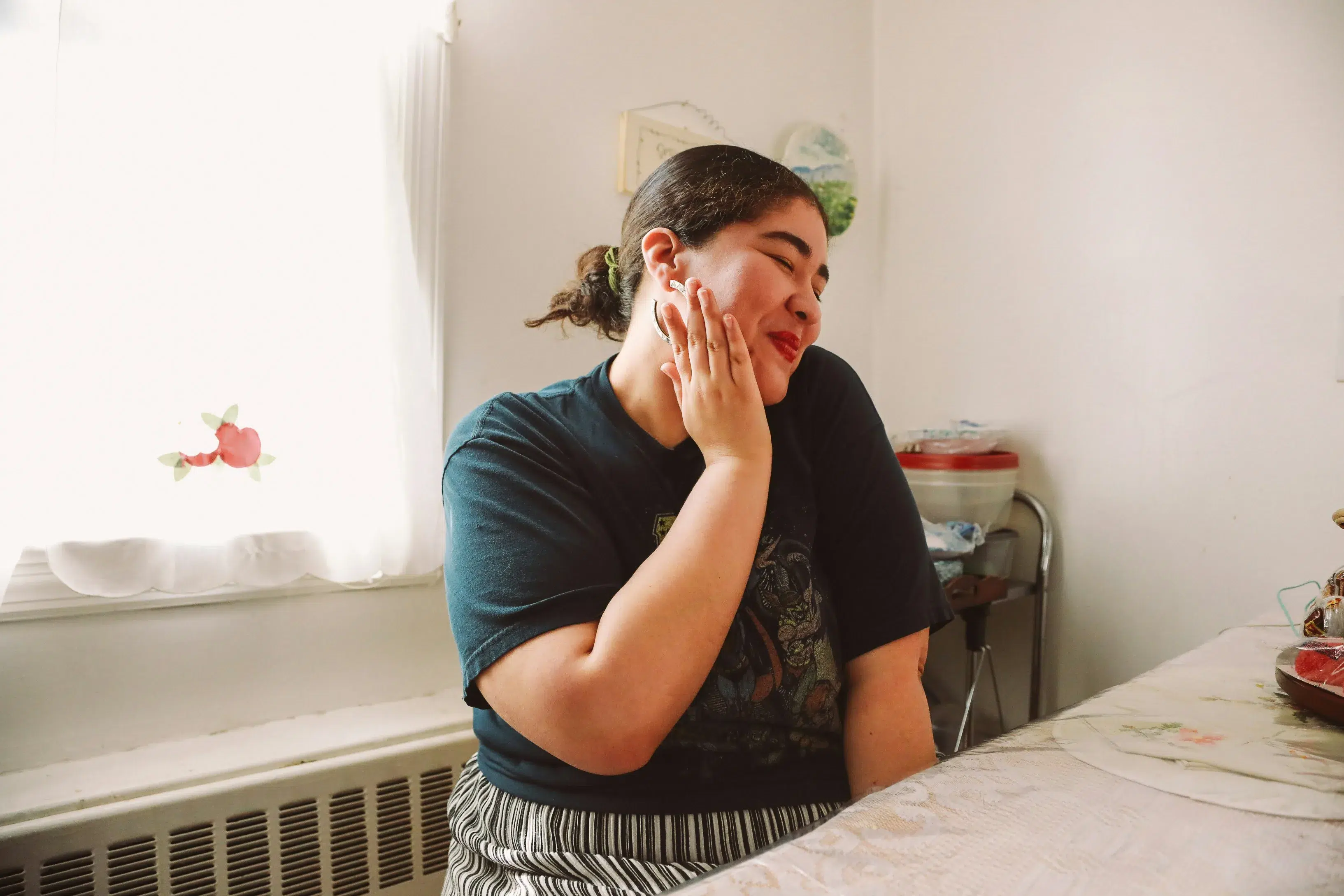 A young woman sits in her apartment smiling, ready to start her credit improvement journey with her new york credit union