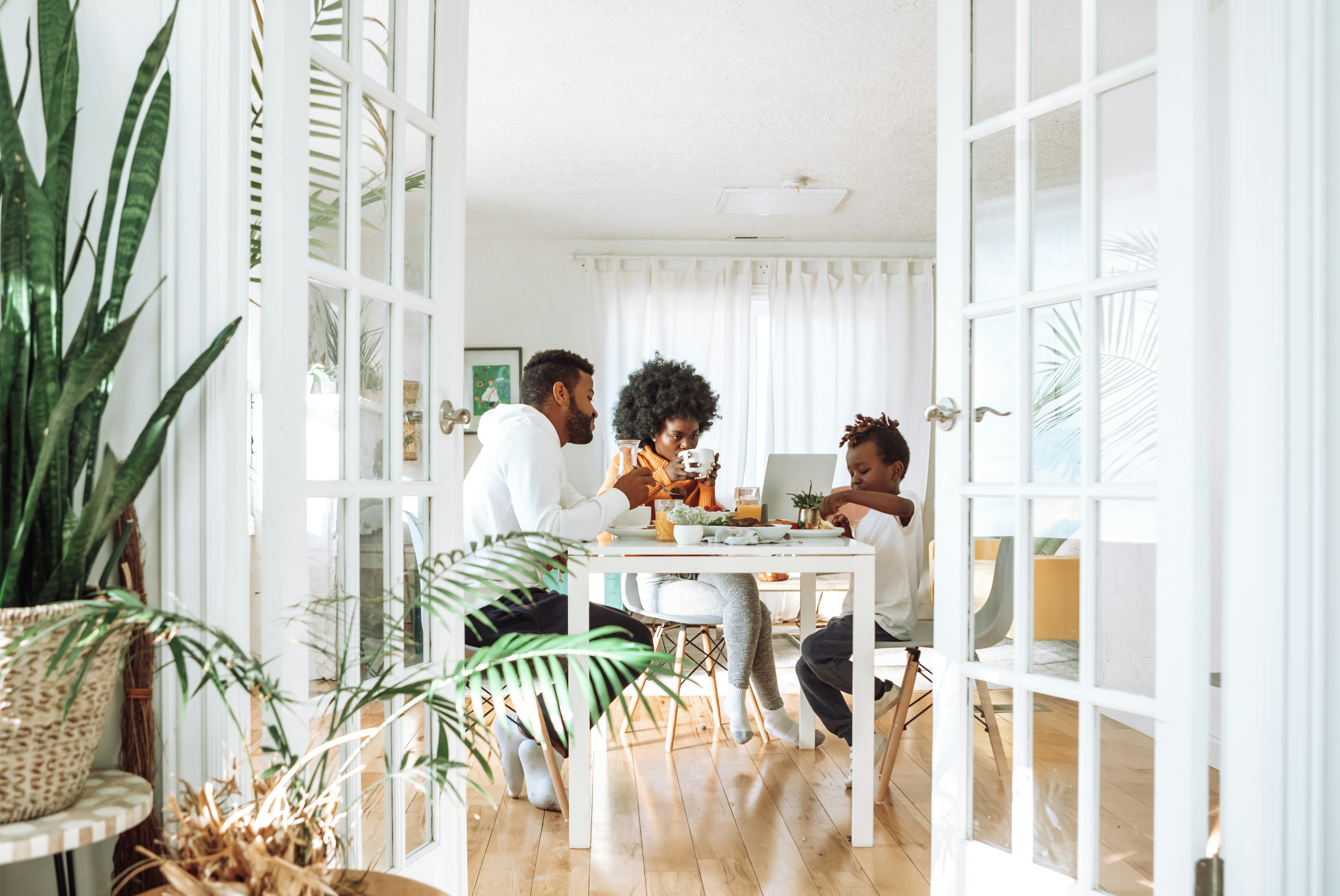 A family has breakfast together at the kitchen table. The parents are members of a New York credit union.