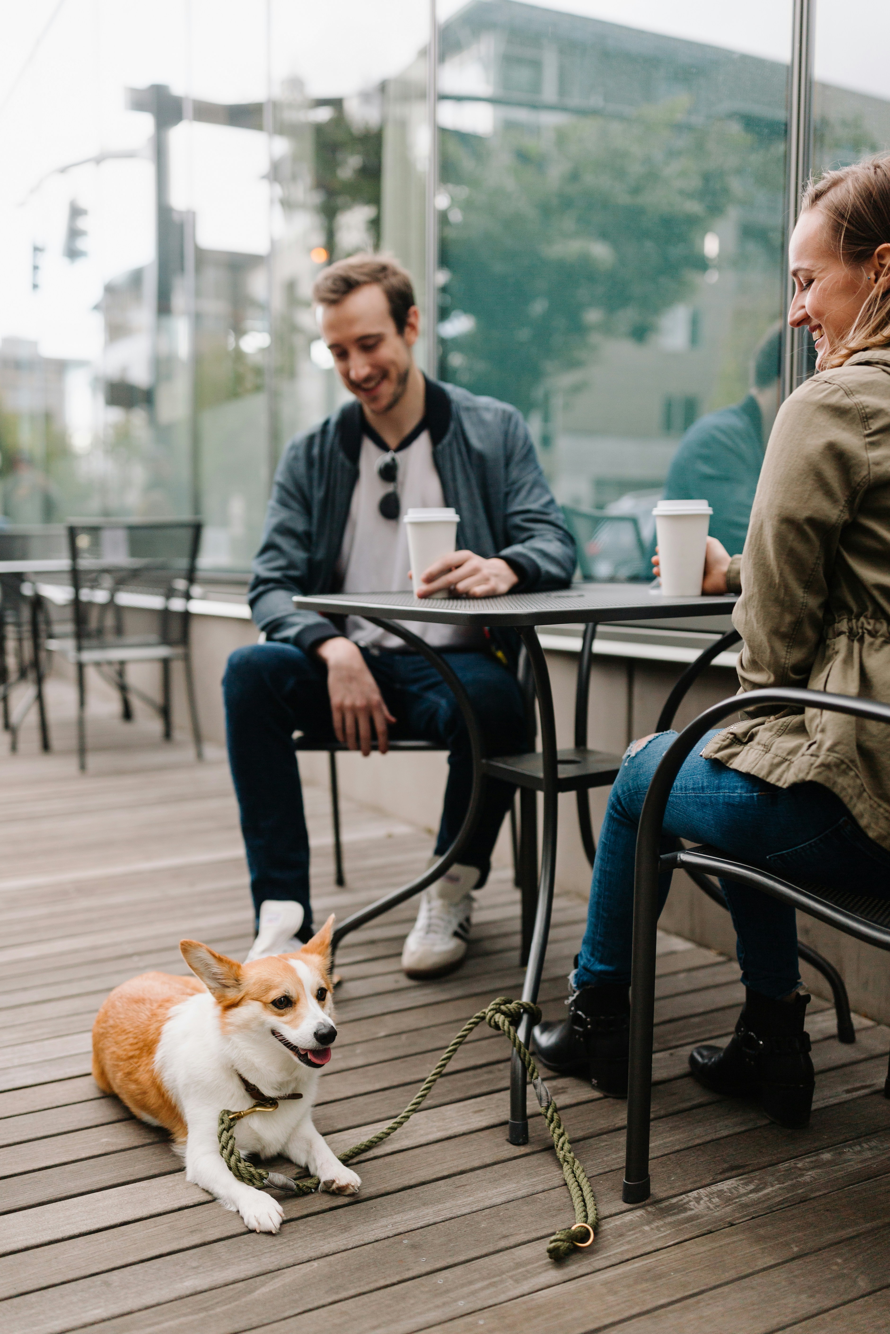 two friends getting coffee with their dog, talking about how much they enjoy their Palisades CU membership
